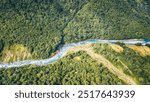 Aerial of green glades, forest and pebbly riverbed at Wilkin river, shot in bright spring light from above, Otago, South Island, New Zealand