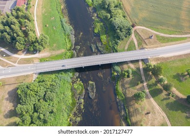 Aerial high angle view of car driving over bridge. River flowing under bridge