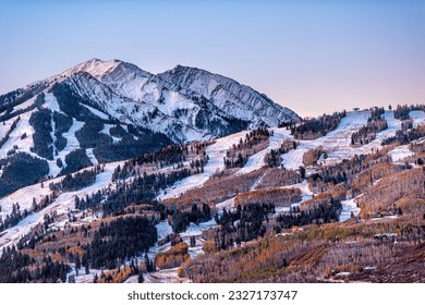 Aerial high angle view of ski resort town city of Aspen, Colorado after winter snow on Buttermilk mountain slopes with valley in autumn fall