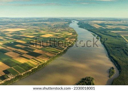 Aerial high view of colorful fields on high bank of Danube river in Serbia
