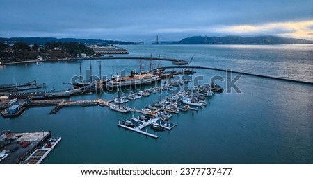Aerial Hyde St Pier with large historical boats docked near regular vessels at dusk