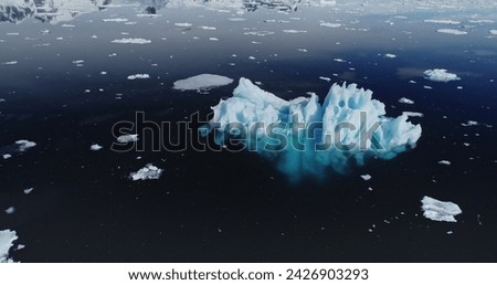 Aerial of icebergs floating in ocean bay. Environment problem concept of global warming with melting snow, ice, glacier. Dramatic nature landscape with powerful message of climate change in Antarctica