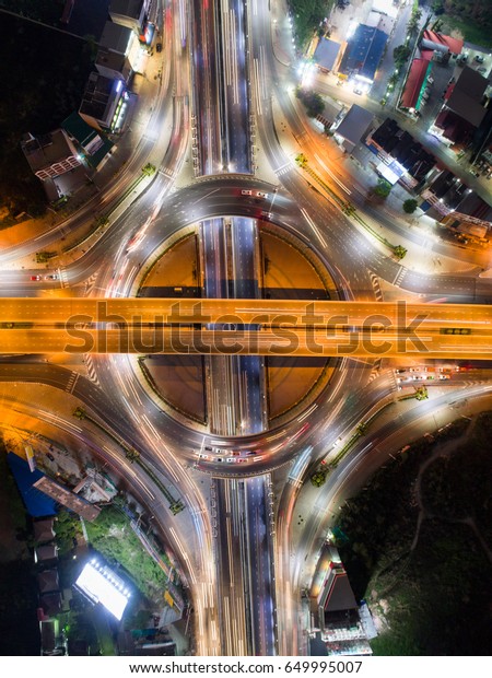 Aerial image of a city in Thailand, with a road\
roundabout and an expressway with car lots. a lovely street, a\
panoramic view, the heart of the city, and a bustling business\
district