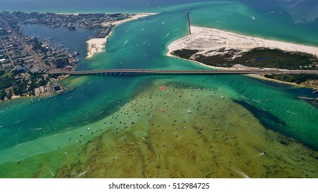 Aerial image of the Destin Harbor in Destin, FL, showing the East Pass, Crab Island, and the Marler Bridge. 
