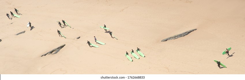 Aerial image of longboard surf group walking on the beach