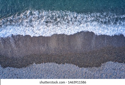 Aerial image of pebble beach natural background. Camera looks straight down. Crete, Greece