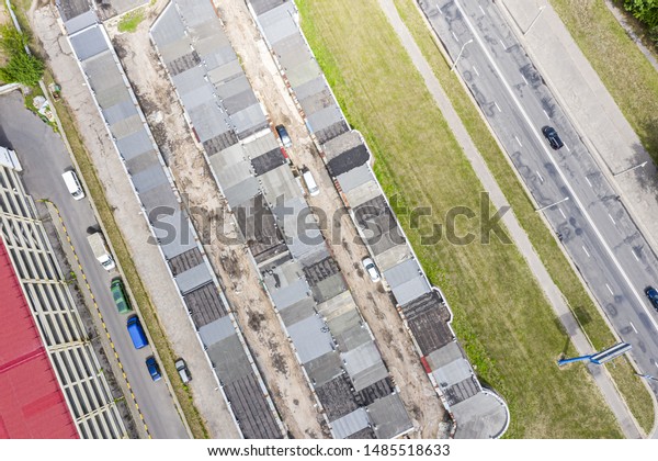 aerial image of roof of car garages and parked cars.
birds eye view