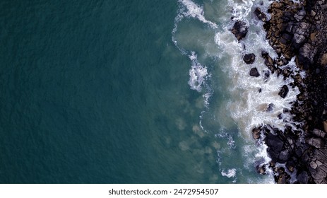 Aerial image of waves hitting rocks - Powered by Shutterstock