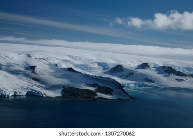 Aerial Images Of Mountains With Snow, Icy Sea And Icebergs In Antartica.