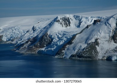 Aerial Images Of Mountains With Snow, Icy Sea And Icebergs In Antartica.