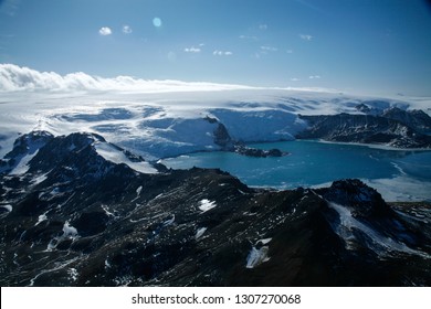 Aerial Images Of Mountains With Snow, Icy Sea And Icebergs In Antartica.