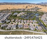 Aerial images over the Trilogy 55+ and older community in Brentwood, California with beautiful homes with solar, surrounded by hills with vineyards and mt.diablo