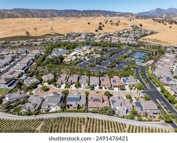 Aerial images over the Trilogy 55+ and older community in Brentwood, California with beautiful homes with solar, surrounded by hills with vineyards and mt.diablo