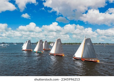 Aerial images of traditional skûtsjesilen, sailing in tradition Frisian flat bottomed former large sailing boats. Regatta, sailing event on Frisian, Fryslan, lakes, with typical Dutch skies.