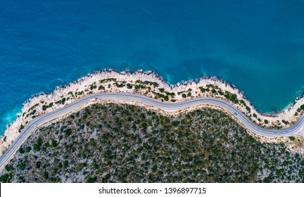 Aerial landscape of coastline and a road seascape. Car drives down the empty asphalt road running along the sunny Mediterranean shoreline of Turkey. Tourist car cruises down the scenic coastal road . - Powered by Shutterstock