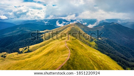 Aerial landscape photography. Dramatic morning view from flying drone of Svydovets mountain range with old country road. Misty outdoor scene of Carpathian mountains, Ukraine, Europe. 