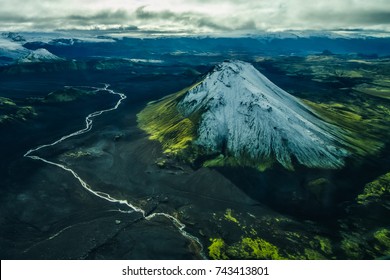 Aerial landscape of river flowing near snowcapped volcano in Iceland