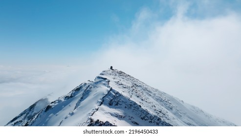 aerial landscape of snow mountain peak above clouds under the blue sky with a lot of copy space - Powered by Shutterstock