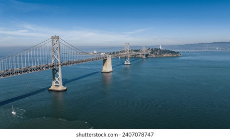 aerial landscape view of area around San Francisco–Oakland Bay Bridge, a double-decked suspension spans - across San Francisco Bay - Car and Truck traffic driving on both decks on Interstate 80