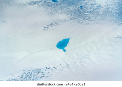 aerial landscape view of Greenland with snow covered surface and bright blue meltwater lakes in middle of icecap - The Arctic nature is UNESCO World Heritage - Powered by Shutterstock