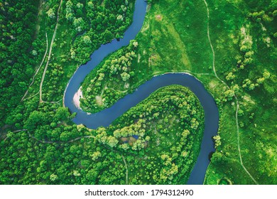 Aerial landscape of winding river in green field, top view of beautiful nature background from drone, seasonal summer landscape with copy space