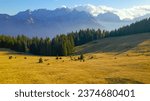 AERIAL: Majestic view of high mountaintops in Julian Alps on a sunny autumn day. Enchanting scenery in the Alpine world. Beautiful mountain range rising above forest and valley shrouded in gentle mist