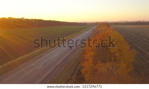 Aerial:\
motorbike on the asphalt road at sunset\
time