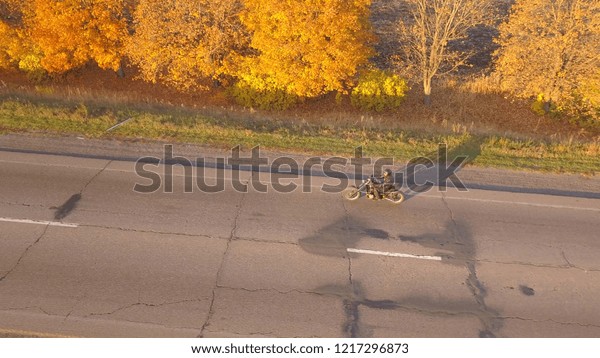 Aerial:\
motorbike on the asphalt road at sunset\
time