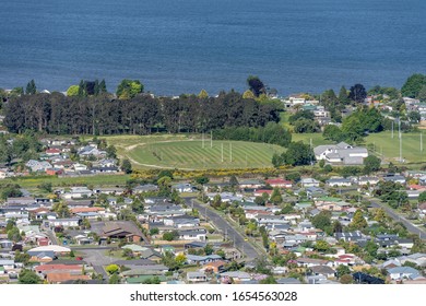 Aerial Of Neighborhood Rugby Field Near Lake Shore At Touristic Town, Shot In Bright Late Spring Light At Rotorua, North Island, New Zealand
