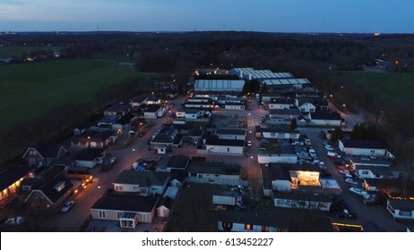 Aerial Night Flight Over Trailer Park Semi-permanent Or Permanent Area For Mobile Homes Or Travel Trailers Showing The Dark Neighborhood With Some Light From Street Lights Illuminating The Street