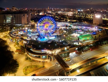 Aerial night scene of Taipei, the vibrant capital of Taiwan, with a view of a Ferris wheel amid other facilities in Taipei Children's Amusement Park & city lights in downtown area across Keelung River - Powered by Shutterstock