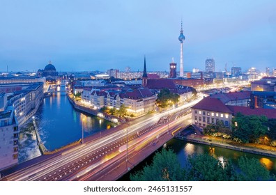 Aerial night skyline of Berlin, Germany, viewed from above Mill Dam Bridge over Spree River, with busy traffic on the streets, dazzling city lights and illuminated Television Tower in Alexander Square - Powered by Shutterstock