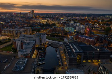 Aerial night time photo taken at sunset of  the area in Leeds known as The Leeds Dock showing the whole of the West Yorkshire city with the sun setting in the background