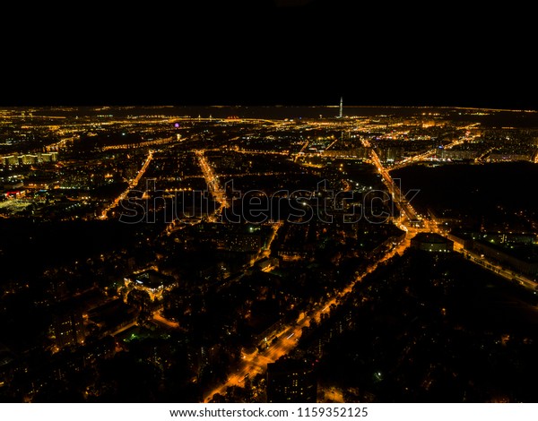 Aerial night view of a big city. Beautiful cityscape\
panorama at night. Aerial view of buildings an roads with car in\
the city at Night time. Aerial bird\'s eye photo. Top view from\
above. 
