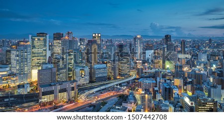 Aerial night view of Osaka city - Asia business city concept image, panoramic modern metropolis bird’s eye view at evening, shot in Umeda Sky Building observatory, Osaka, Japan.