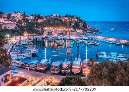 Aerial night view of the picturesque harbor with marina port with cruise tourist ships near the old town of Kaleici in Antalya. Turkish Riviera and travel in resort paradise