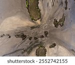 Aerial oblique image of salt flats with tidal river channel showing the contrast between wet and dry areas