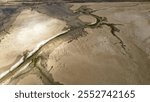 Aerial oblique image of salt flats with tidal river channel showing the contrast between wet and dry areas