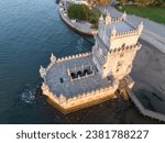 An aerial oblique view of the Belem Tower in Lisbon Portugal, with the 25 de Abril bridge visible in the background. Shot from publicly accessible property