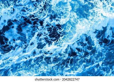 Aerial Ocean Water Blue Surface With Foam And Waves.