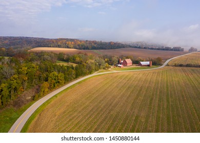 Aerial Over Farm Land And A Forest.  A Road Runs Between The Field And Forest