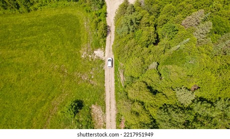 Aerial Overhead Of The Car Driving Off Road At Green Forest Rural Countryside With Trees At Summer. Mountain Forest Road With Single Car In The Wilderness. Adventure And Vacation.