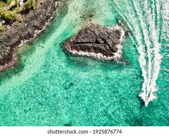 Aerial Overhead Drone View Of A Speedboat Moving At High Speed On Pristine Turquoise Sea In Belle Mare, Mauritius. White Trail On Transparent Water.