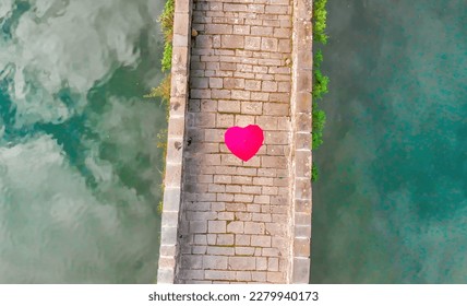 Aerial overhead view of Devils Bridge, Lucca. Red heart shape umbrella on the bridge. - Shutterstock ID 2279940173