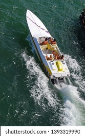 Aerial Overhead View Of Two Men And Two Women Enjoying Enjoying A Very Fast Cruise In A High Powered Speedboat.