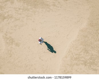 Aerial Overhead View Of Young Man Walking Alone In The Sandy Sea Beach, Abstract Concept Background