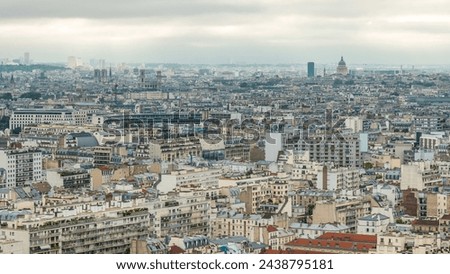 Aerial panorama above houses over rooftops in a Paris city timelapse. Top view with main sightseeings at the morning with cloudy sky