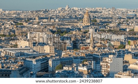 Aerial panorama above houses rooftops in a Paris timelapse. Evening view with les invalides golden dome and long shadows before sunset