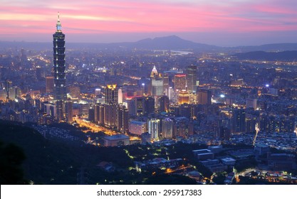 Aerial panorama of busy Taipei City with view of Taipei 101 in downtown area, Tamsui River and distant Mountains in evening twilight ~ A romantic scenery of Taipei City under beautiful evening sky