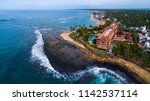 Aerial panorama of the coastline with resorts in the town of Hikkaduwa during low tide, Sri Lanka